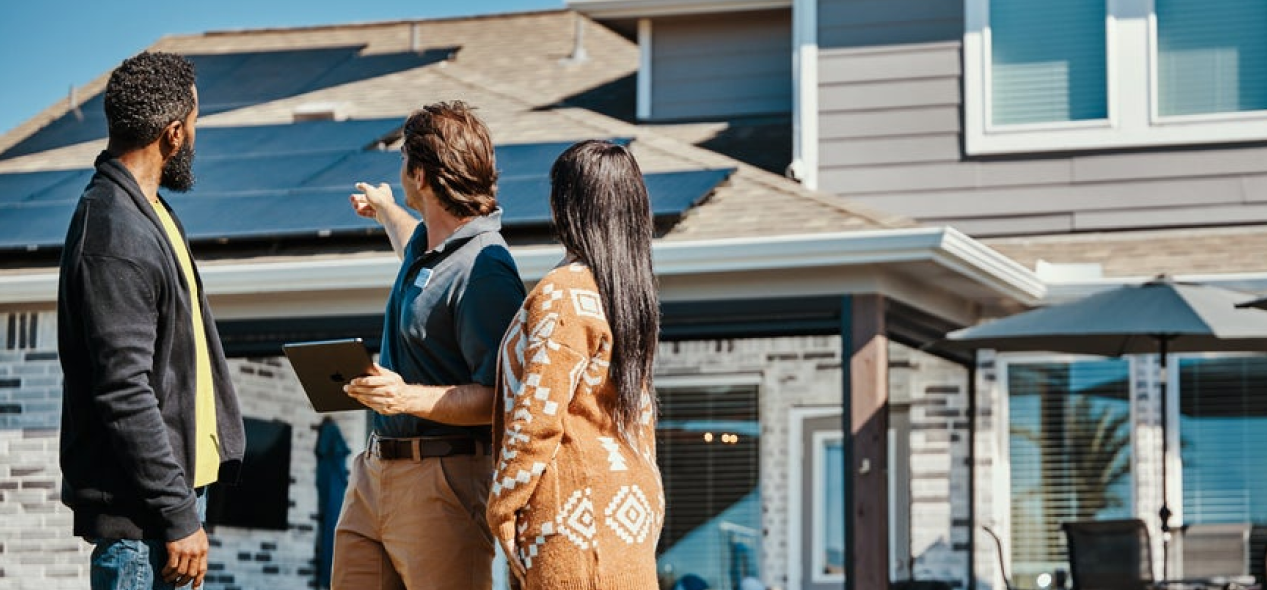 Family looking at solar panels on roof