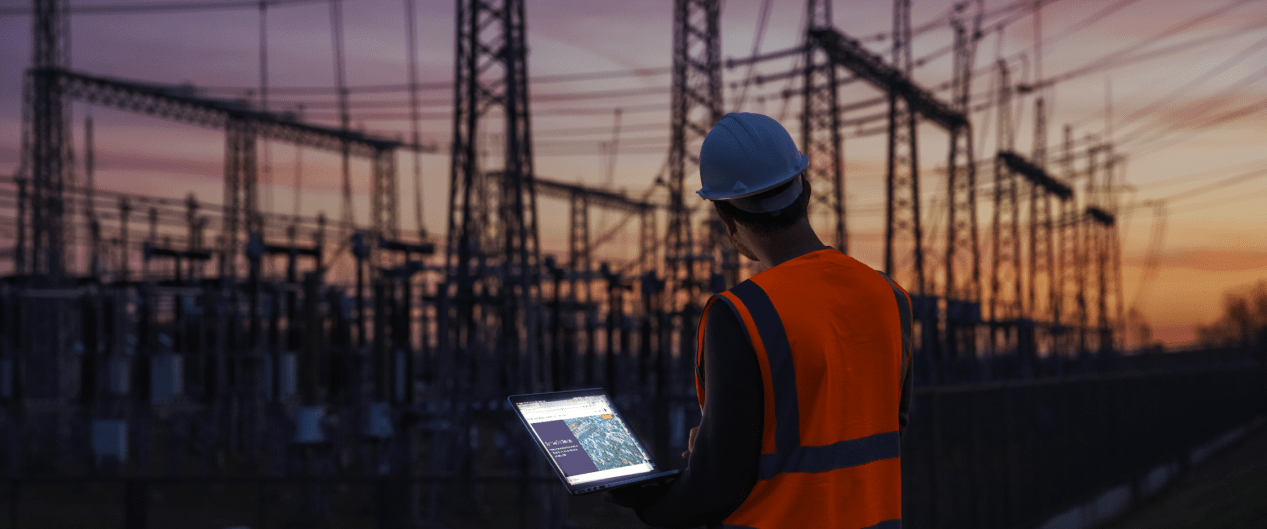worker with tablet in front of power station