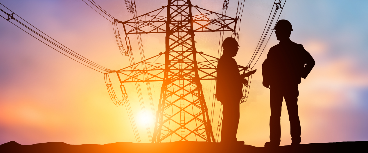a silhouette of a man standing next to a power line