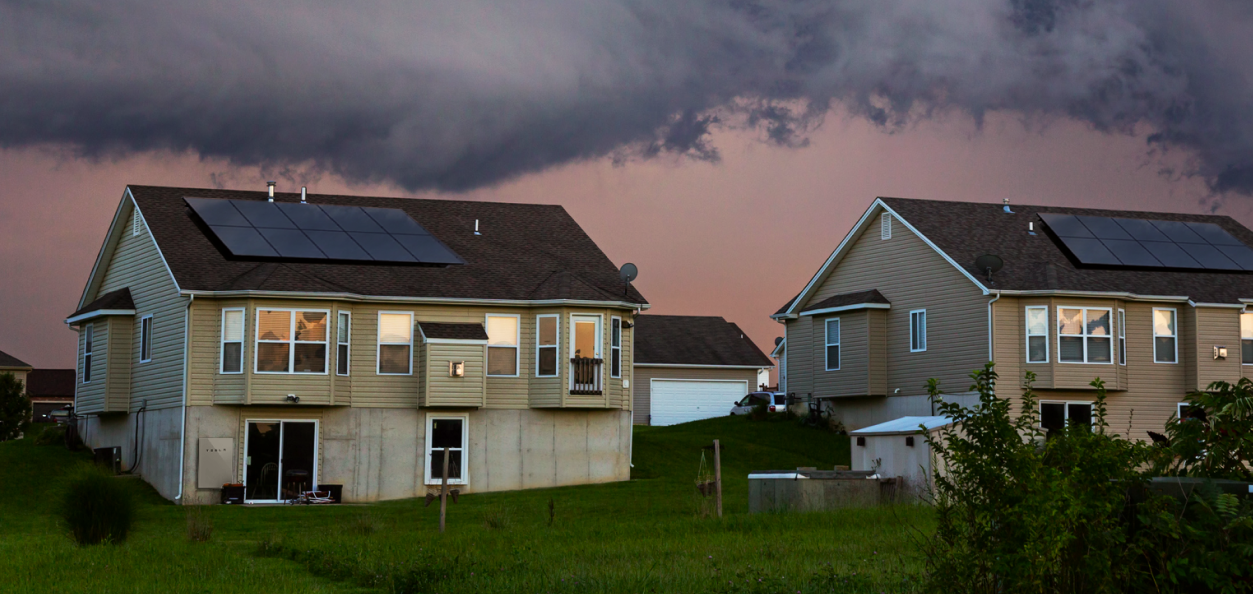 two houses with lights on during a storm