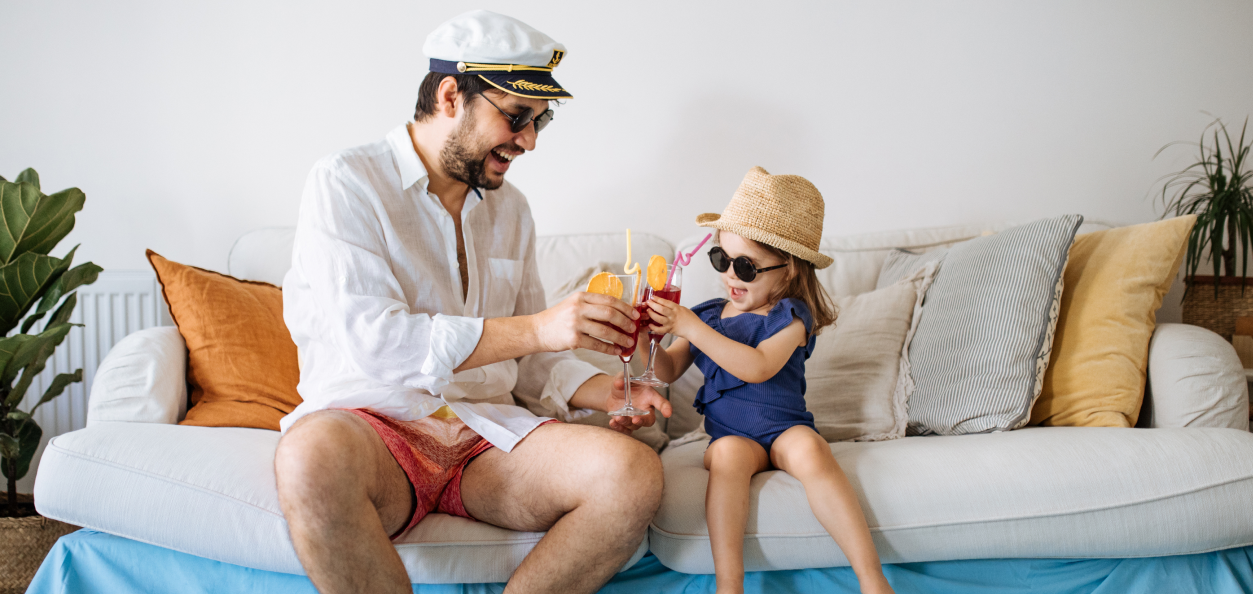 father and daughter drinking juice on couch